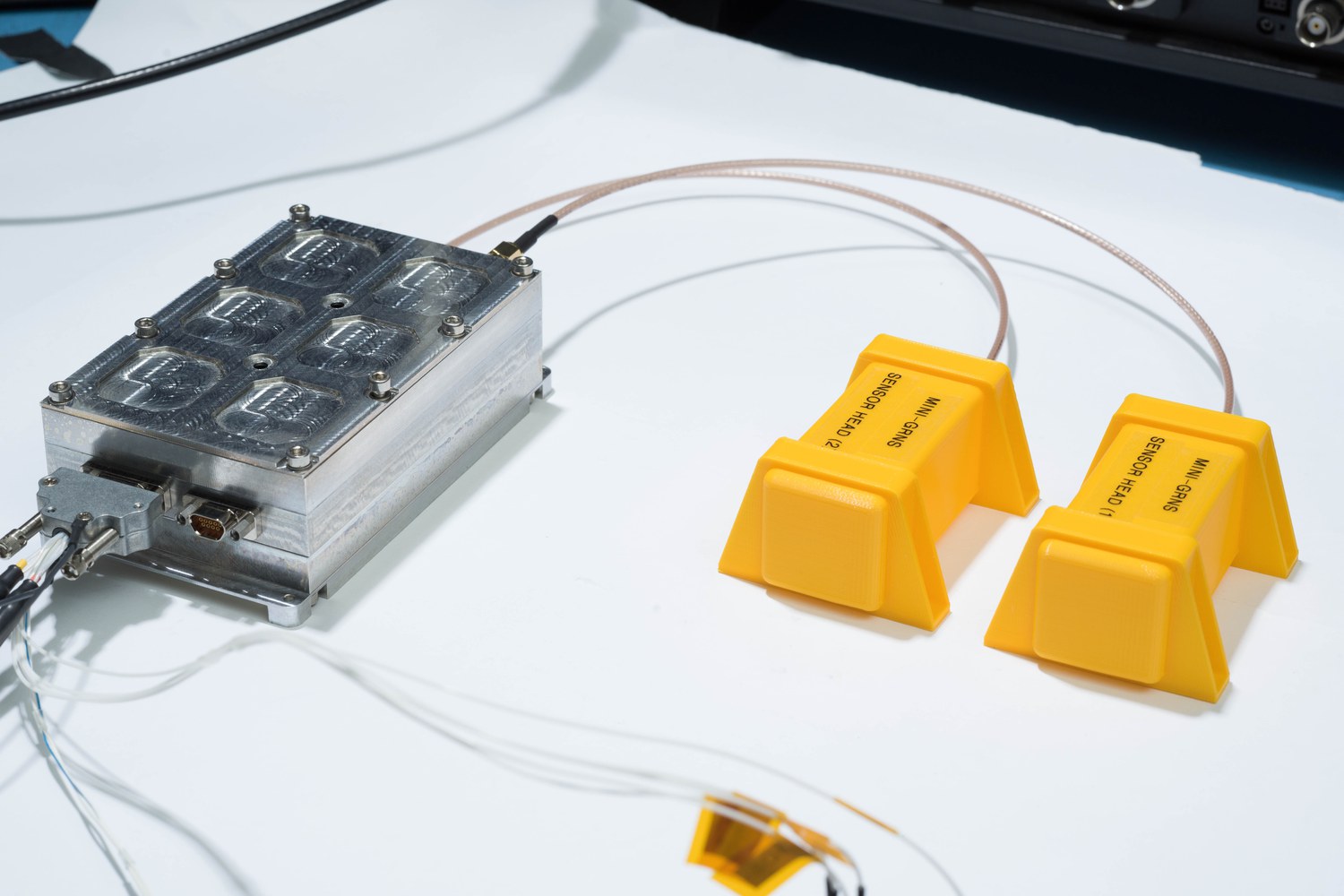 Mini-GRNS electronics stack with two sensor head models on a photo table